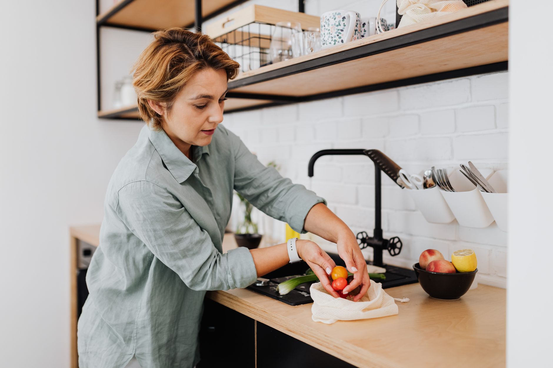 A person preparing fresh vegetables in a bright kitchen, representing NDIS-funded meal preparation support