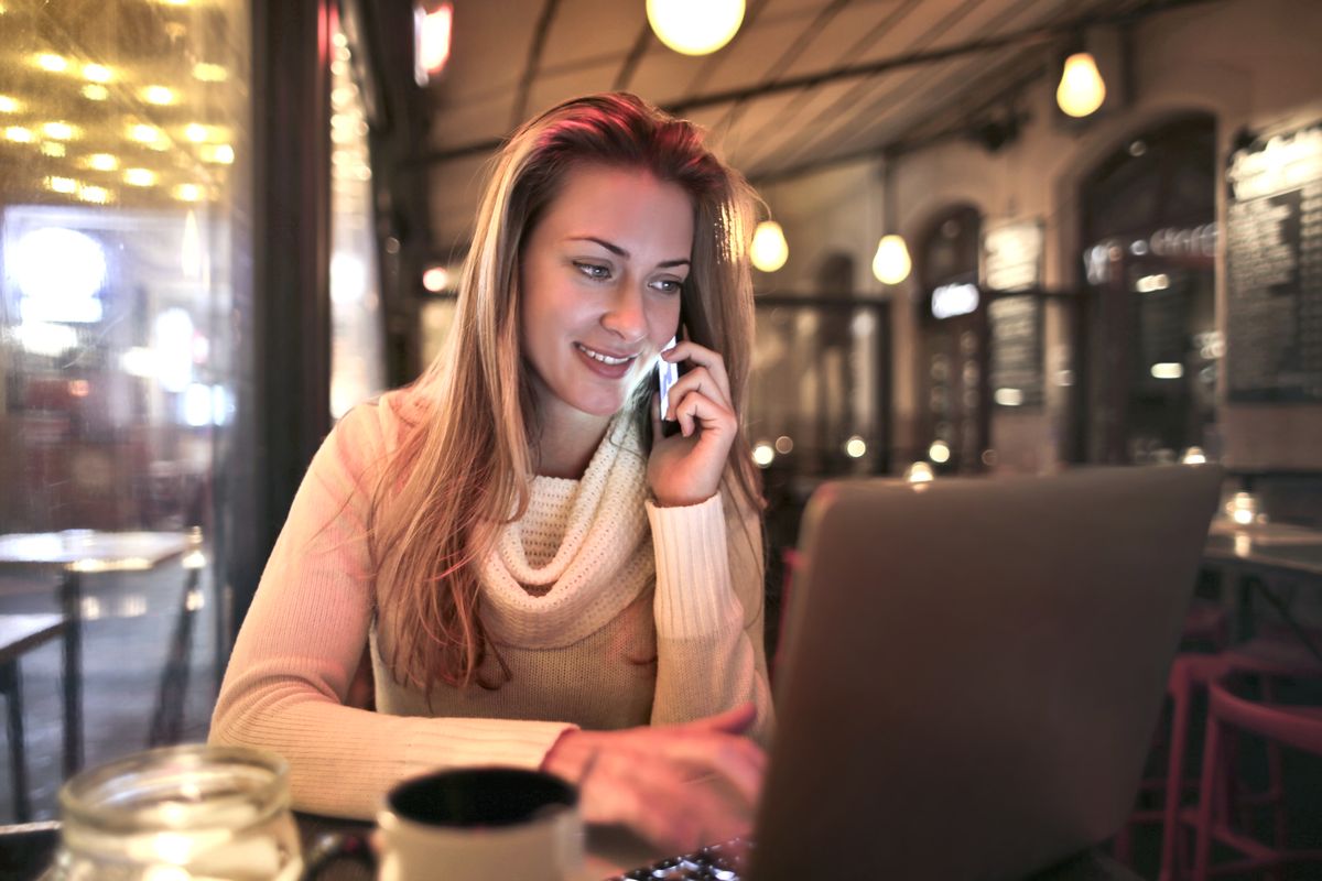 Someone looking at their NDIS plan on a laptop with a cup of coffee, relaxed and in control of their funding